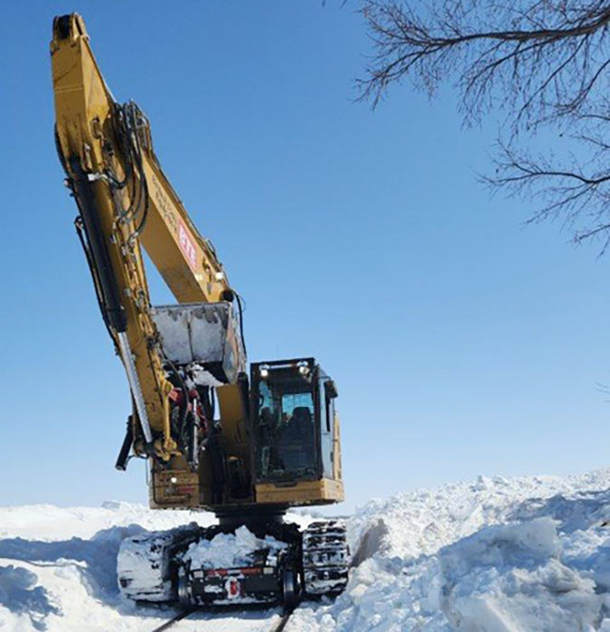 Excavators are among the arsenal for digging out the railroad.