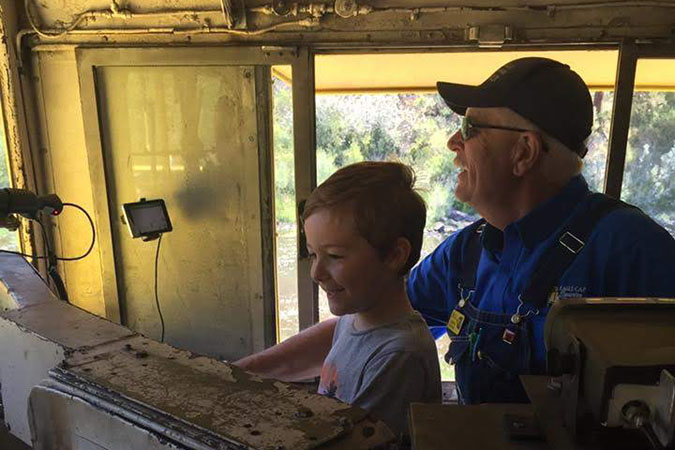 Alexander (at age 5) and an engineer from the Eagle Cap Excursion Train in the cab of a locomotive